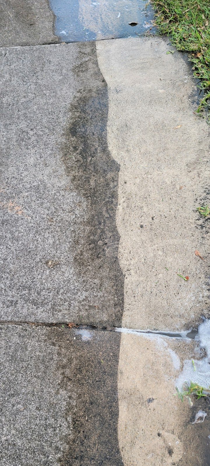 Concrete driveway showing a clean strip next to dirty concrete in Miami